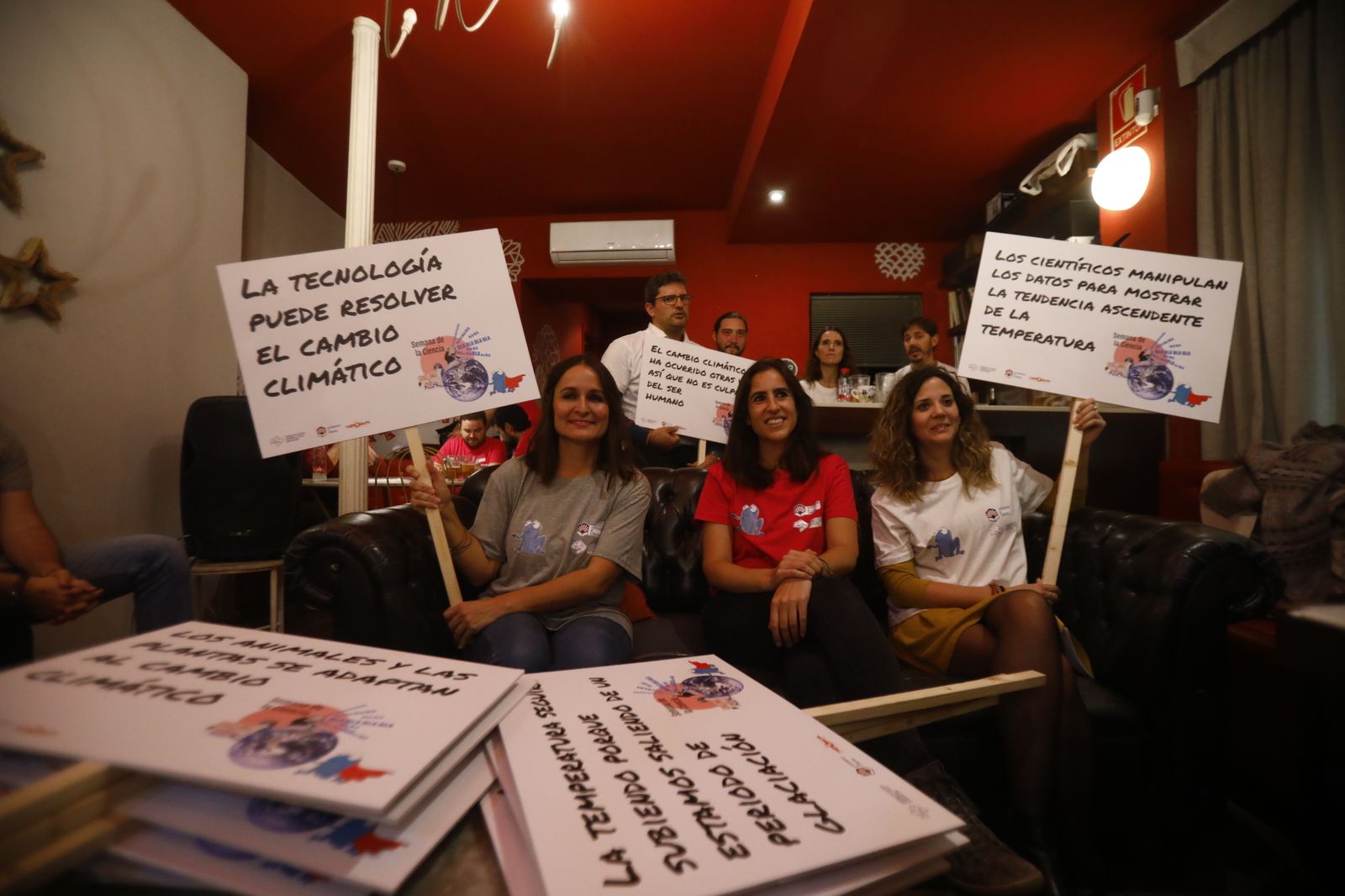 Investigadoras de la UCO sostienen varias pancartas con bulos contra el cambio climático.