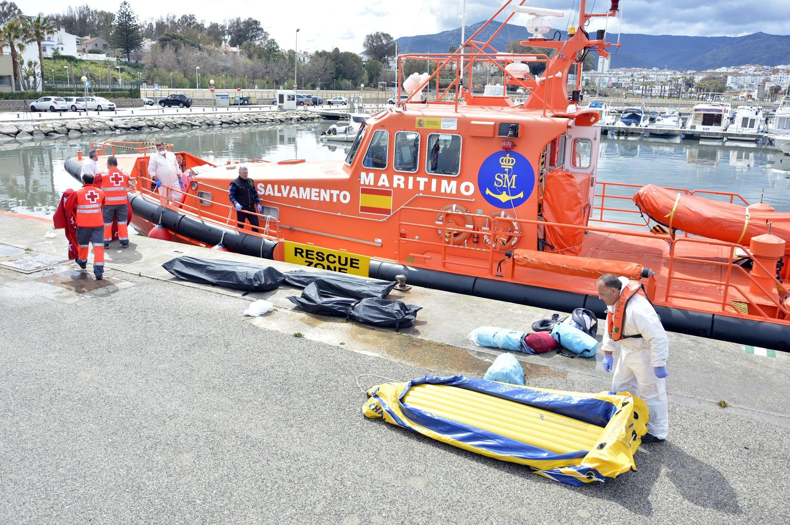 Los cadáveres de los tres inmigrantes, en bolsas negras en el puerto de Algeciras. En primer término, la barca de juguete.