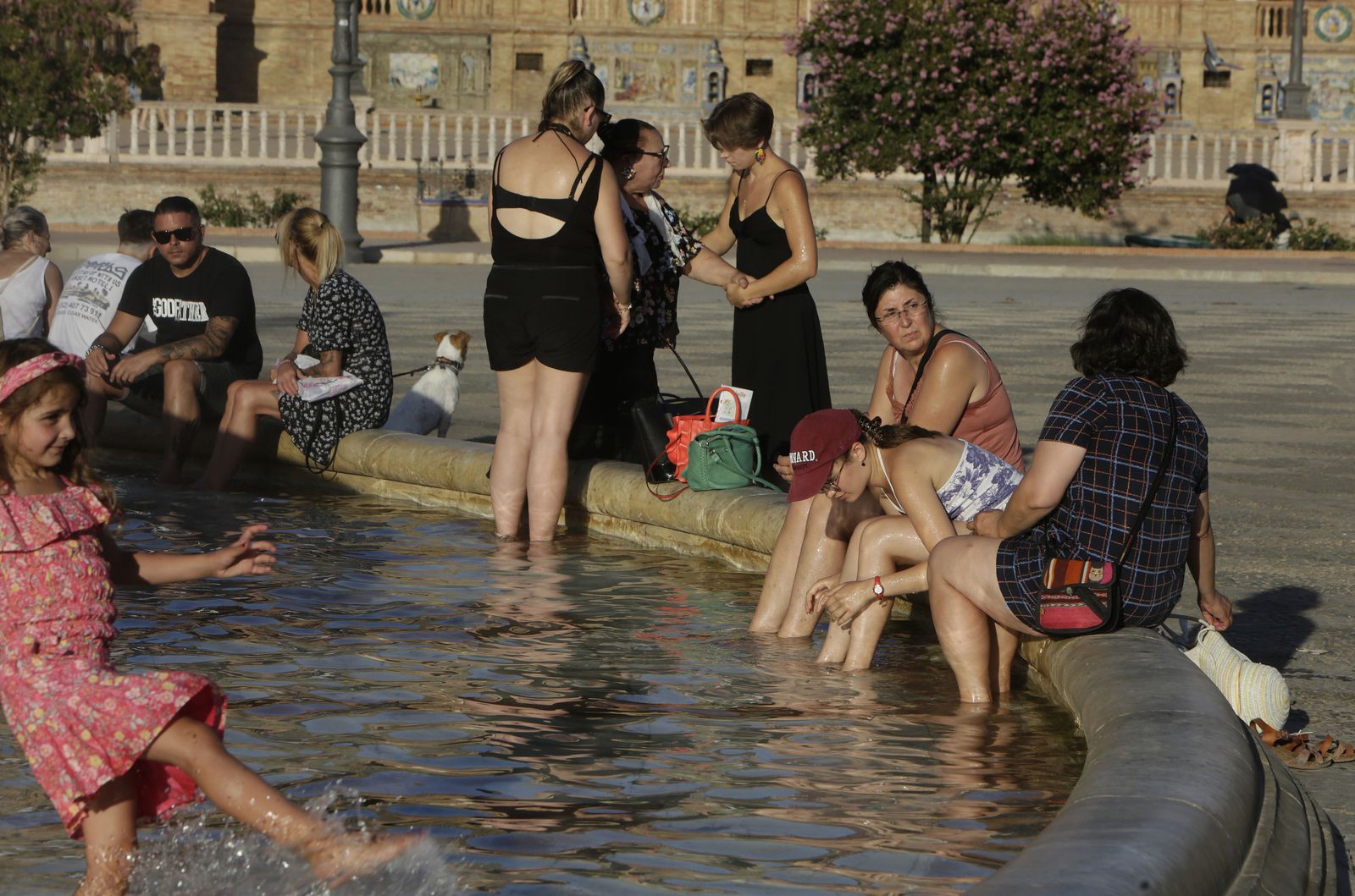 Turistas se refrescan en la fuente de la Plaza de España ante las altas temperaturas del pasado julio en Sevilla.