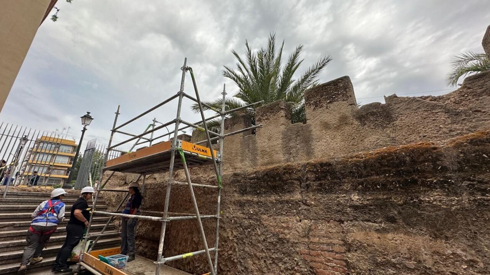 Los restauradores que trabajan en la muralla.