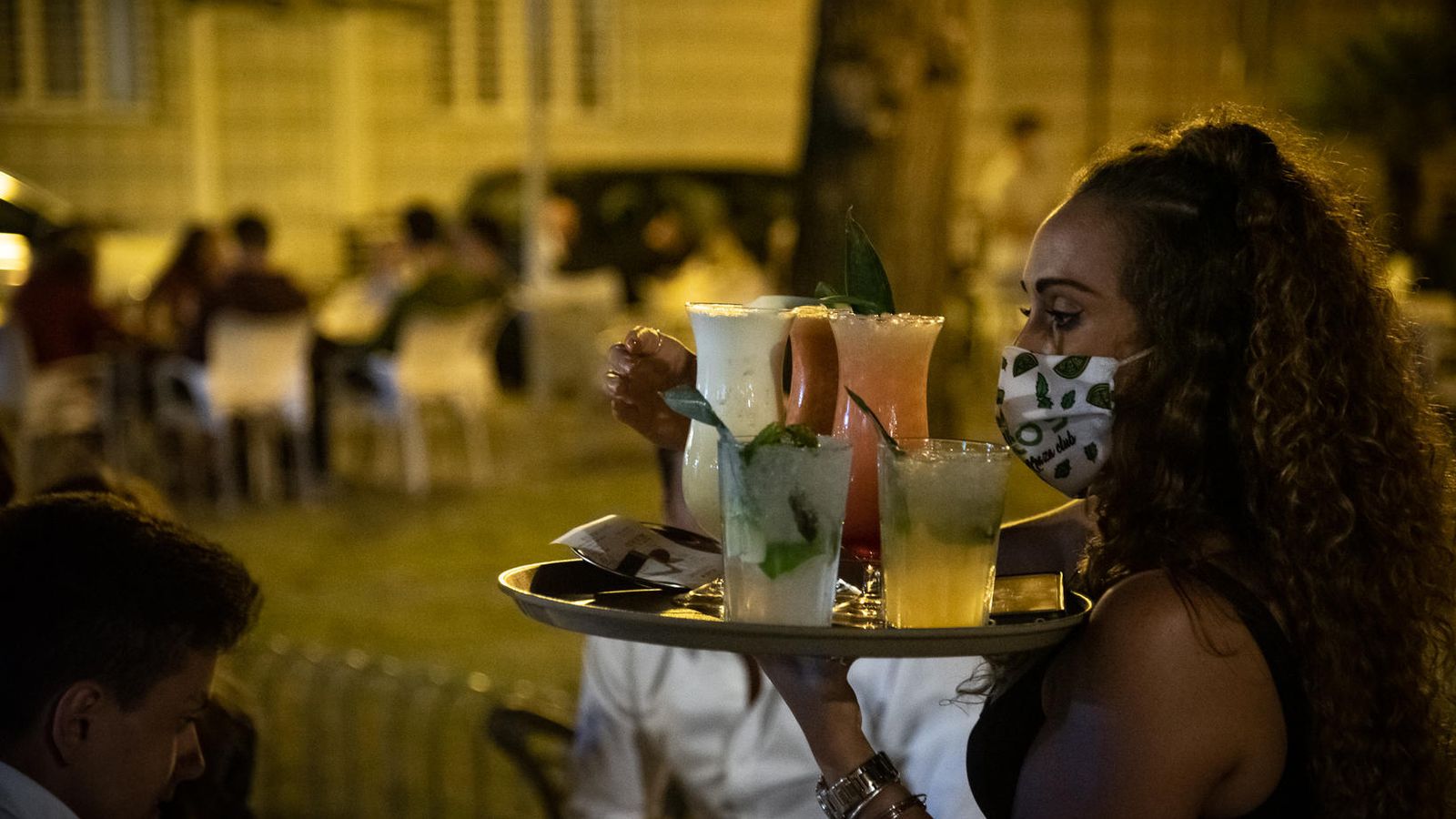 Una camarera con la bandeja repleta de cócteles, en Punta Umbría este viernes.