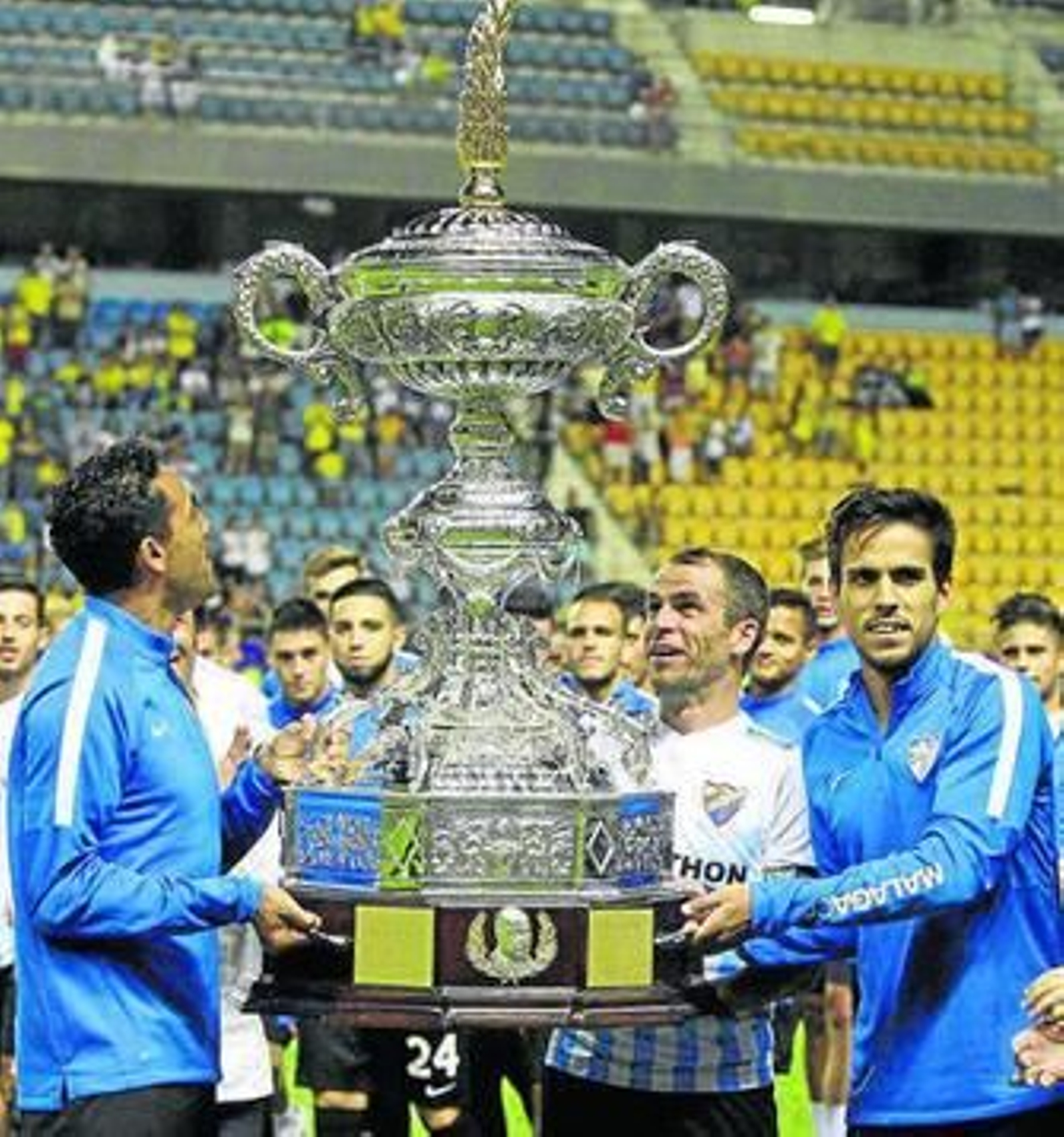 Weligton, Duda y Recio sujetan el trofeo al recibirlo.