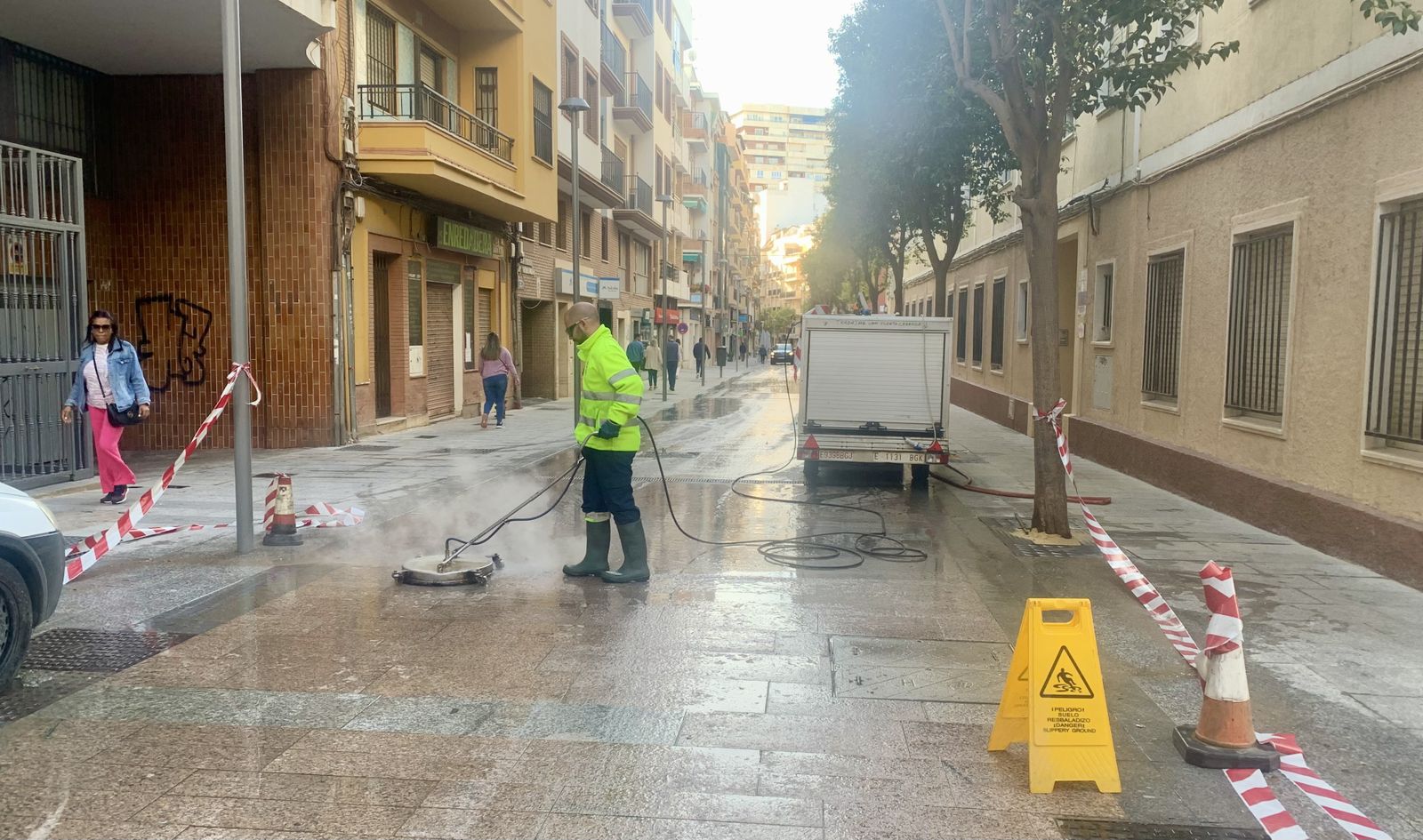 Un operario del Ayuntamiento de Huelva limpia la cera de la calle.