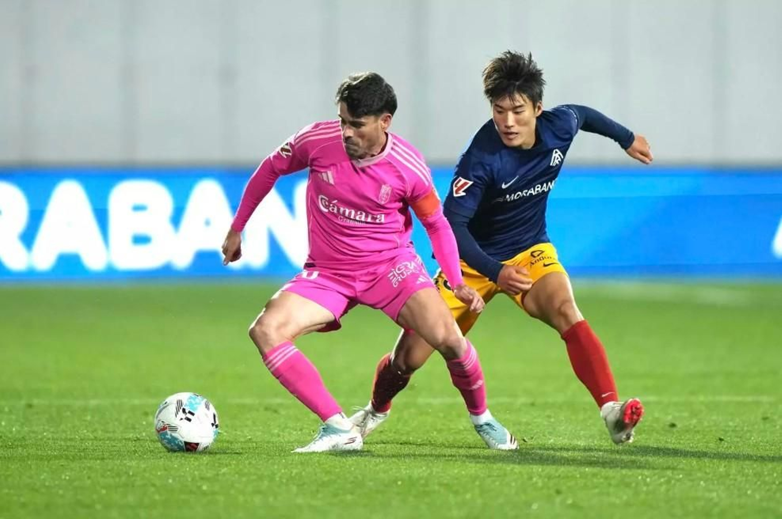 Sergio Ruiz protegiendo el balón ante la presión de Min Su Kim