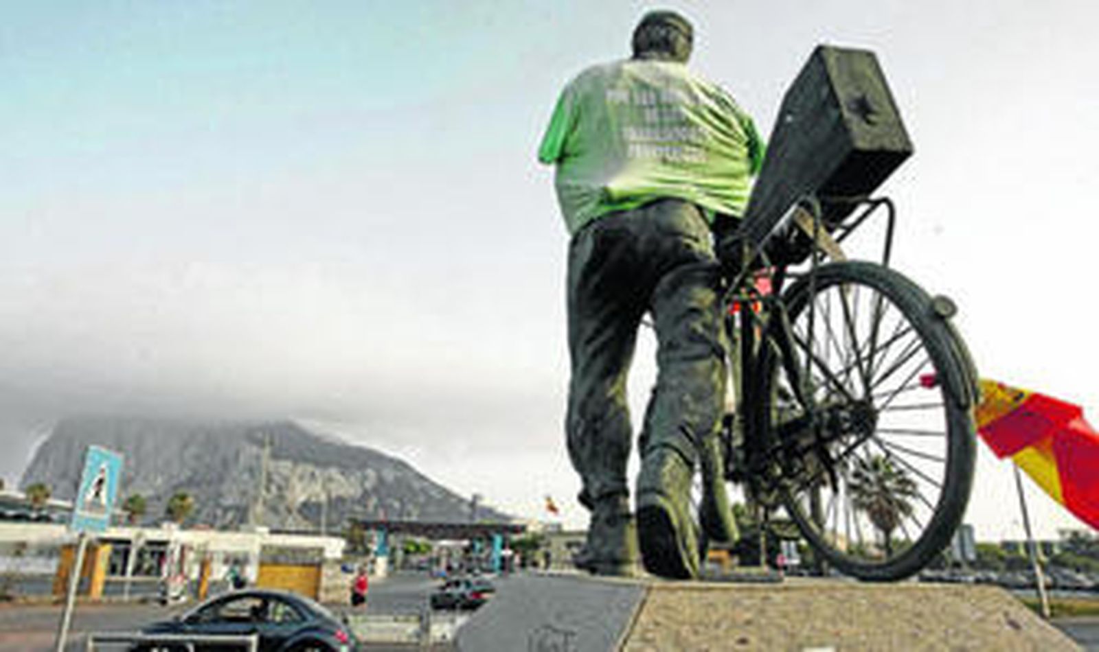 Imagen del monumento al trabajador transfronterizo situada junto a la Aduana, con el Peñón al fondo.