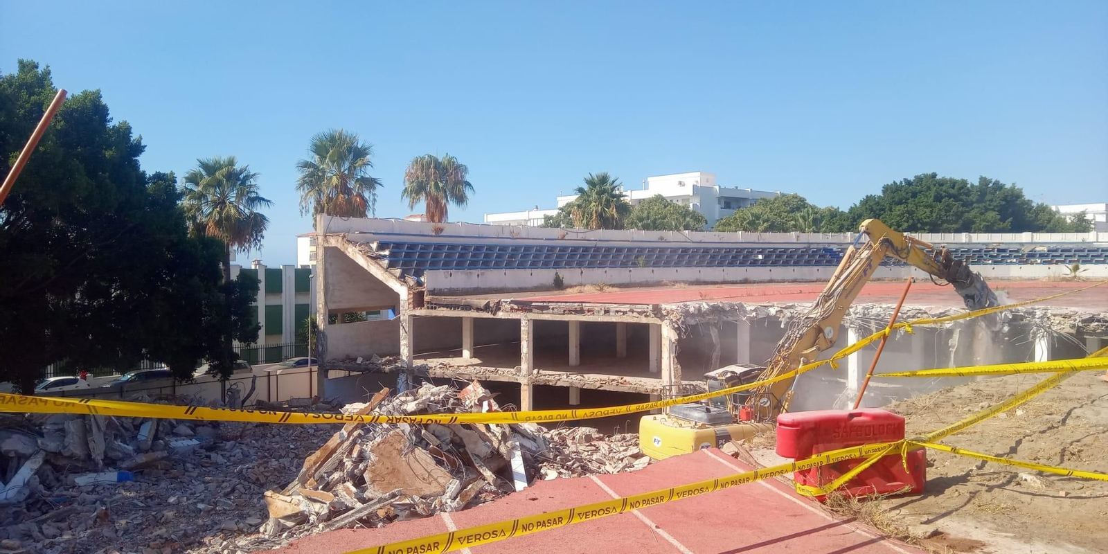 Una máquina excavadora derribando la grada sur, frente al colegio Santa Teresa.