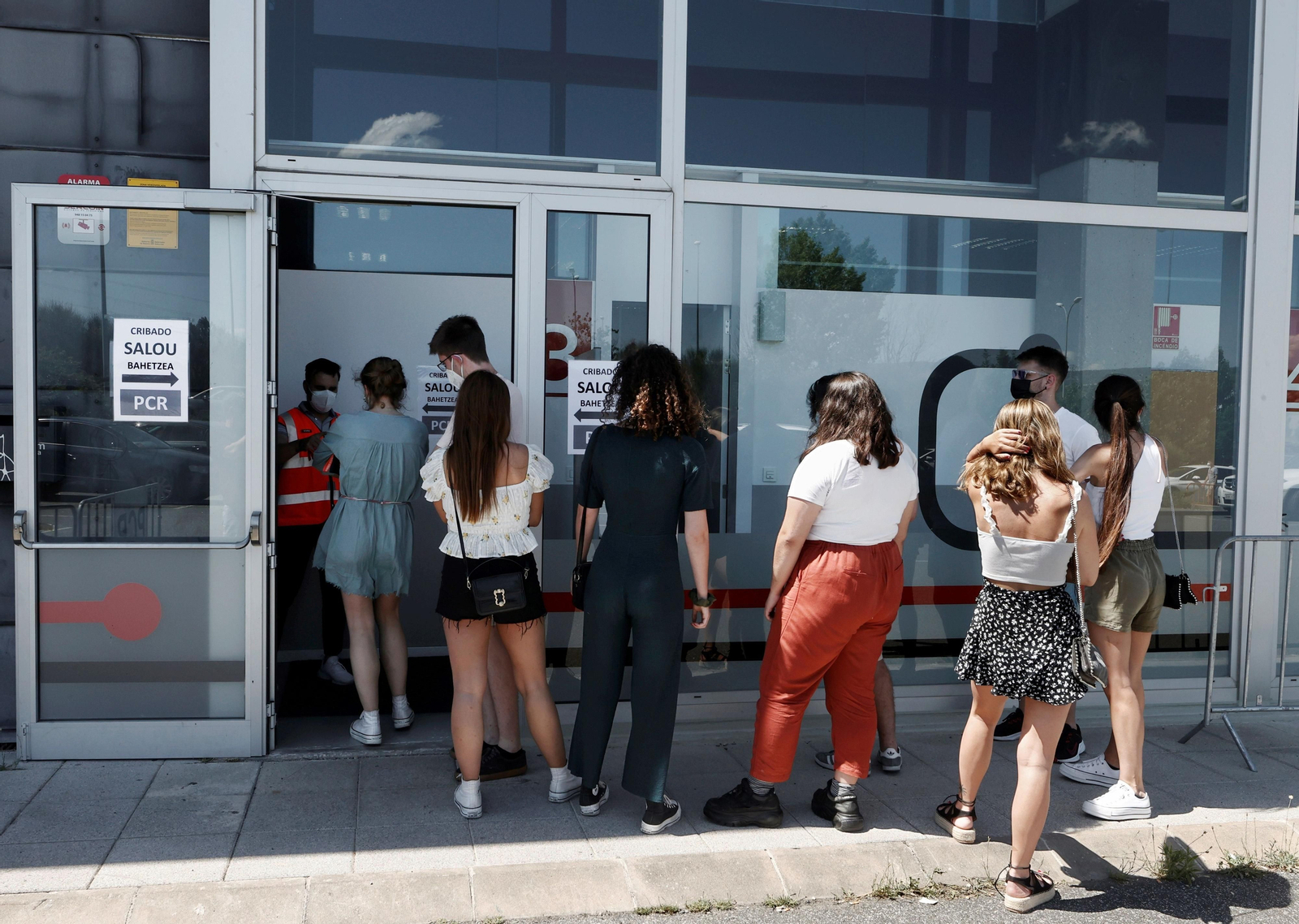 Varios jóvenes de Navarra que estuvieron de vacaciones en Salou, esperando para la realización de un cribado