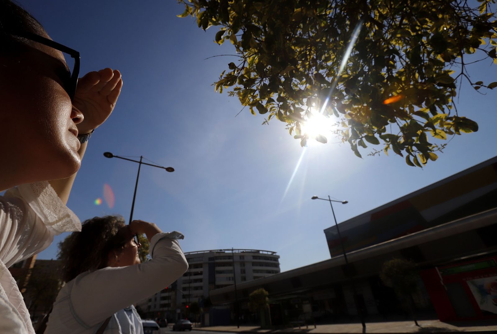 Dos onubenses se protegen del sol.