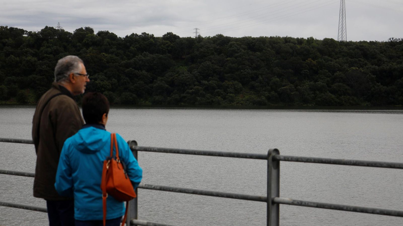 Dos personas observan el embalse de San Rafael de Navallana.