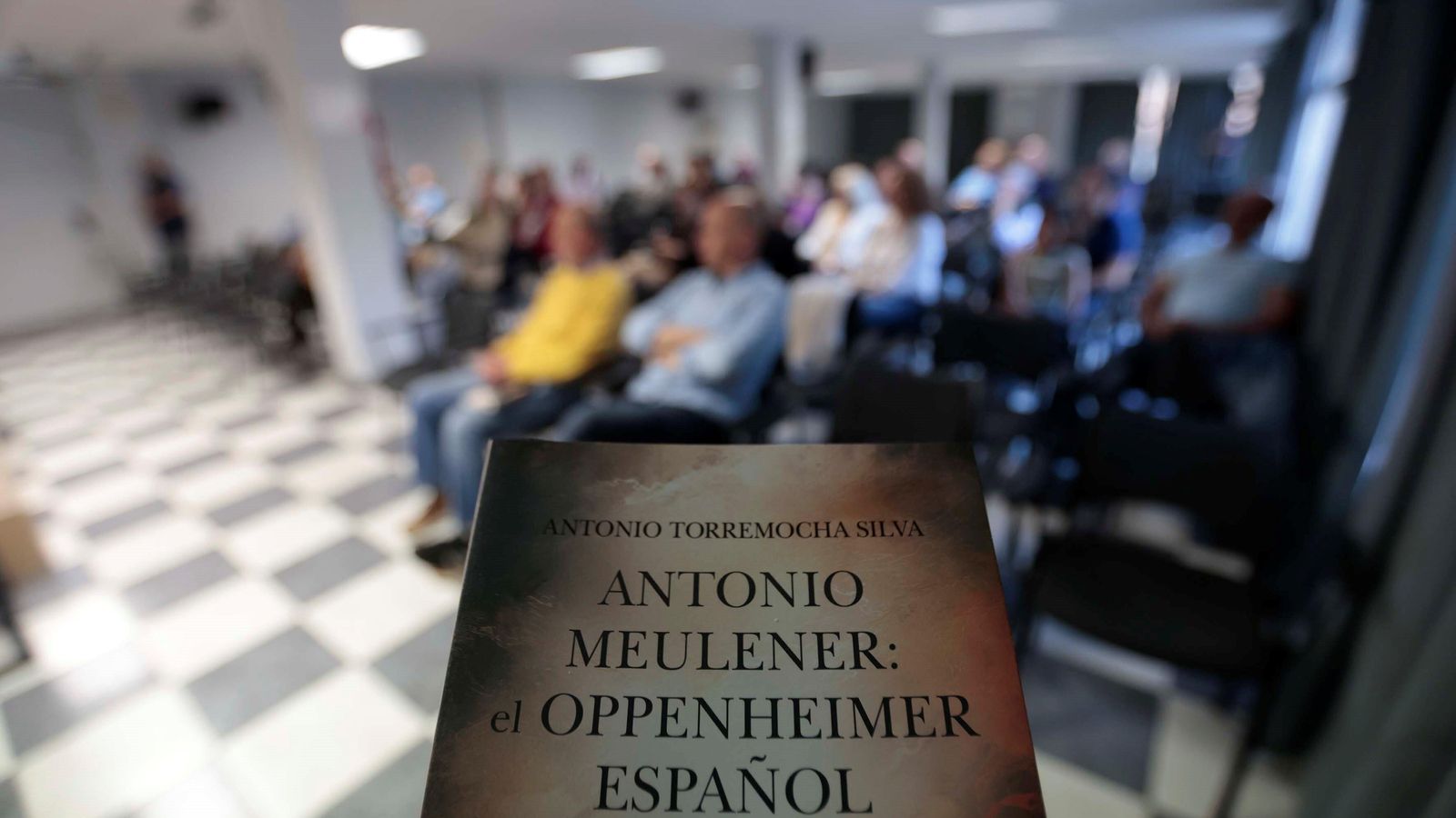 Portada de la novela y el público durante la presentación. Portada de la novela y el público durante la presentación.