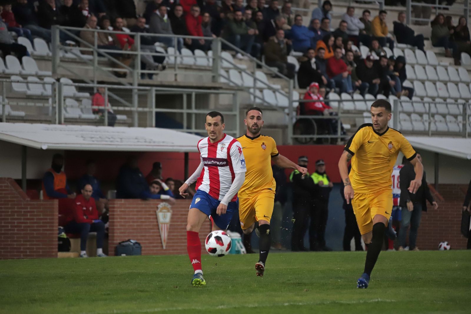 El albirrojo Zafra se escapa de dos jugadores del Utrera en el Nuevo Mirador.