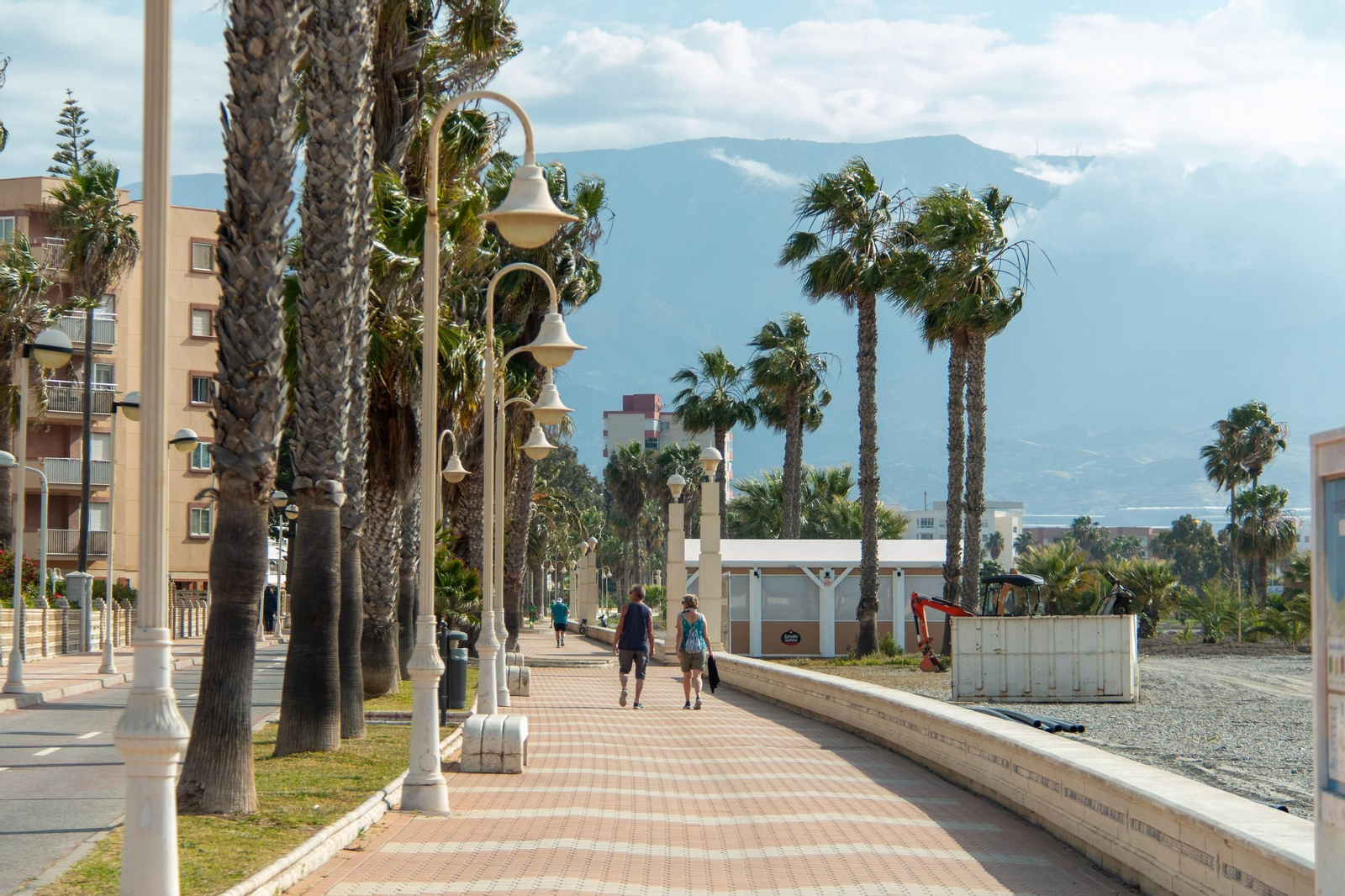 Unas personas por el paseo marítimo Rey Balduino de Motril