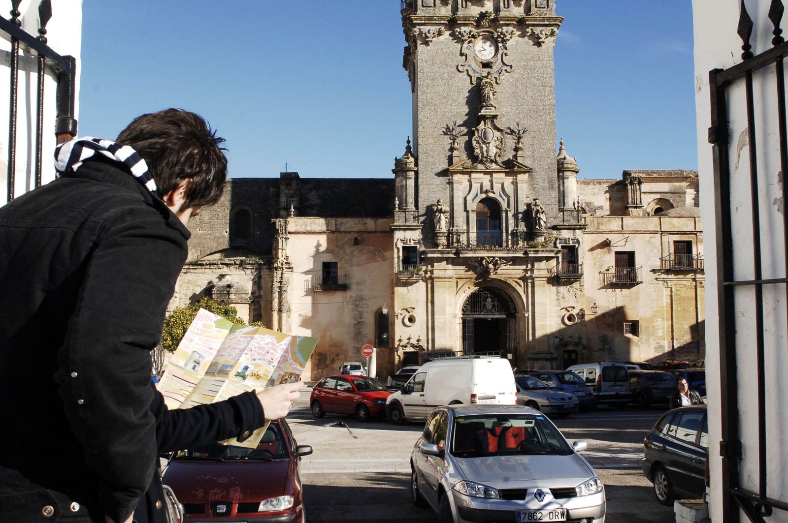 Un turista consulta un mapa delante de la basílica menor de Santa María, en la plaza del Cabildo.
