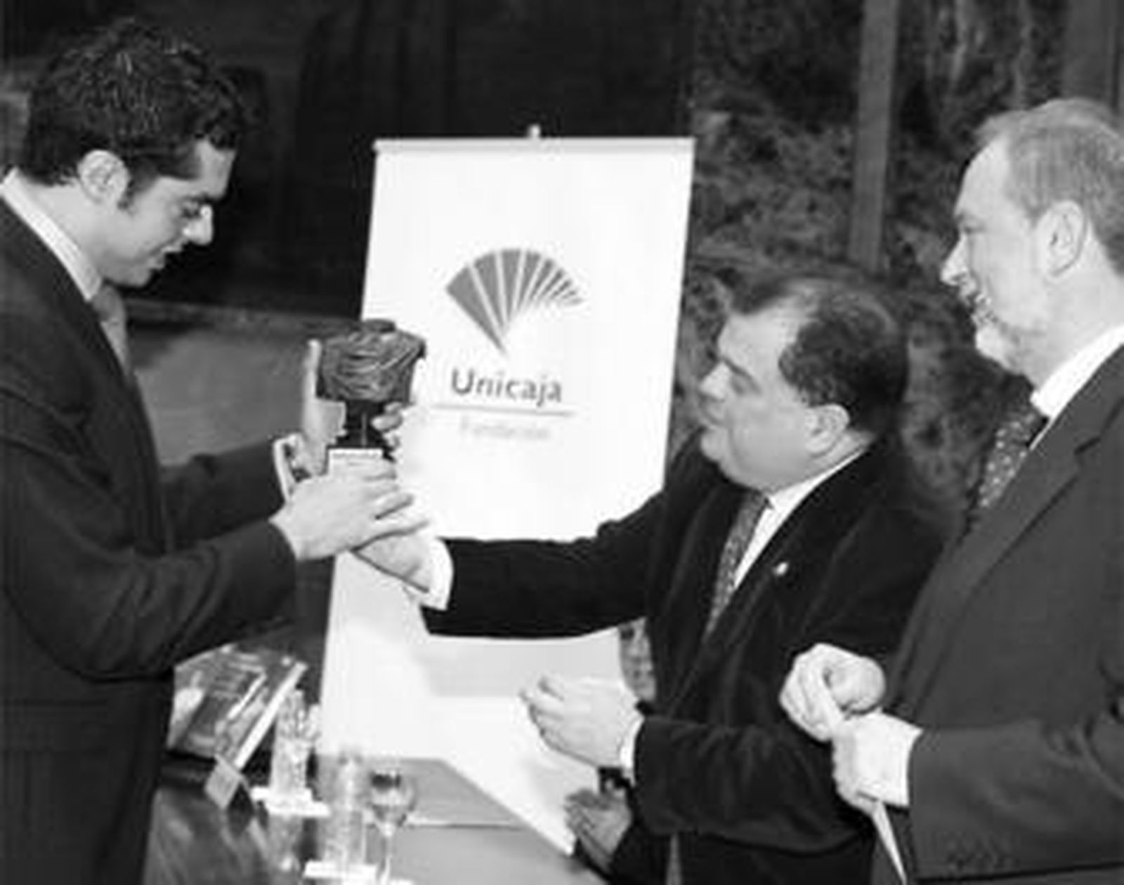 Antonio Castillo y Felipe Faraguna, director de Obra Social de Unicaja, felicitan a Pérez Azaústre.