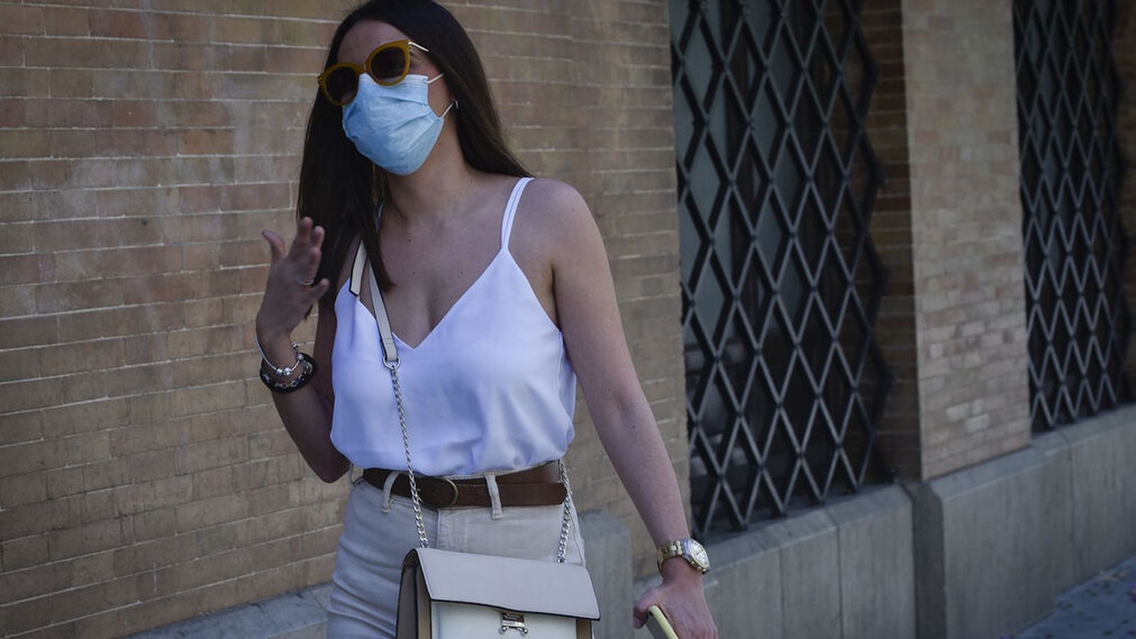Una joven acalorada con la mascarilla.
