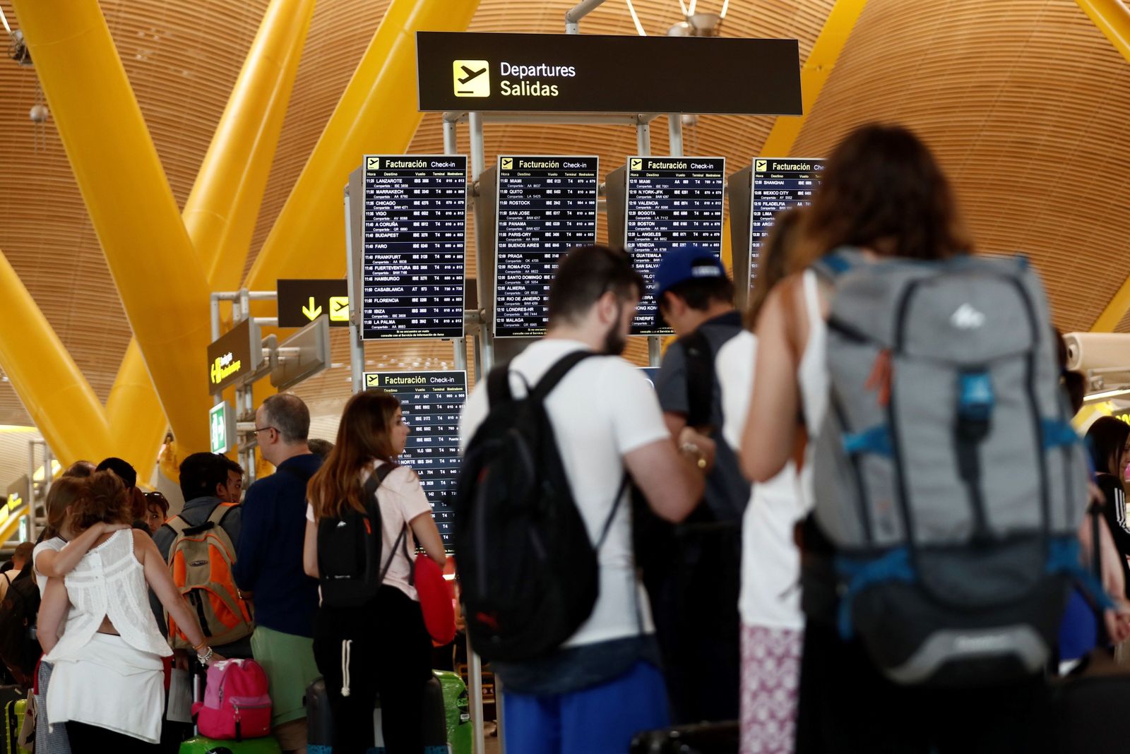 Varios pasajeros hacen cola en el aeropuerto de Barajas.