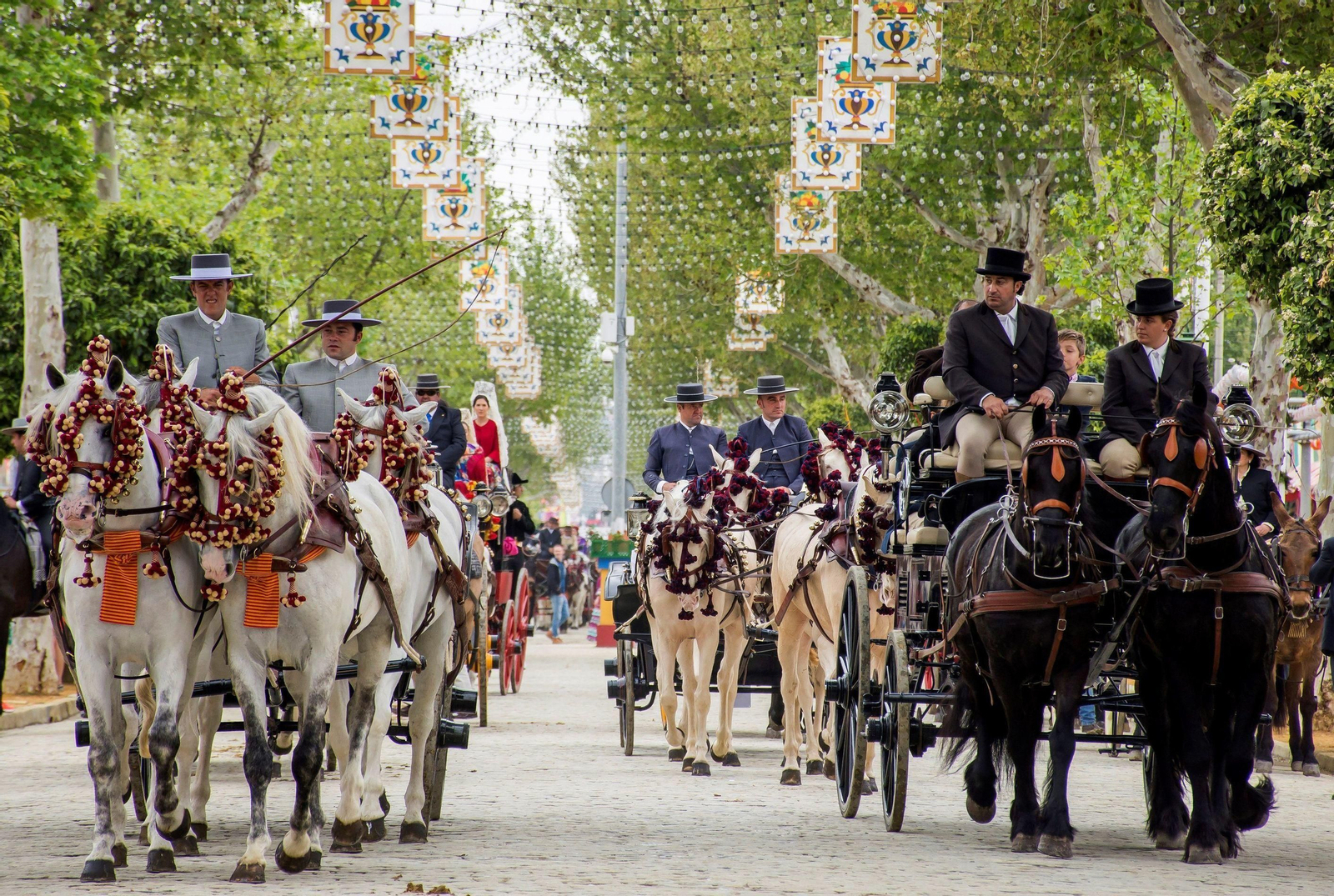 Coches de caballo pasean por una calle del real de la Feria.