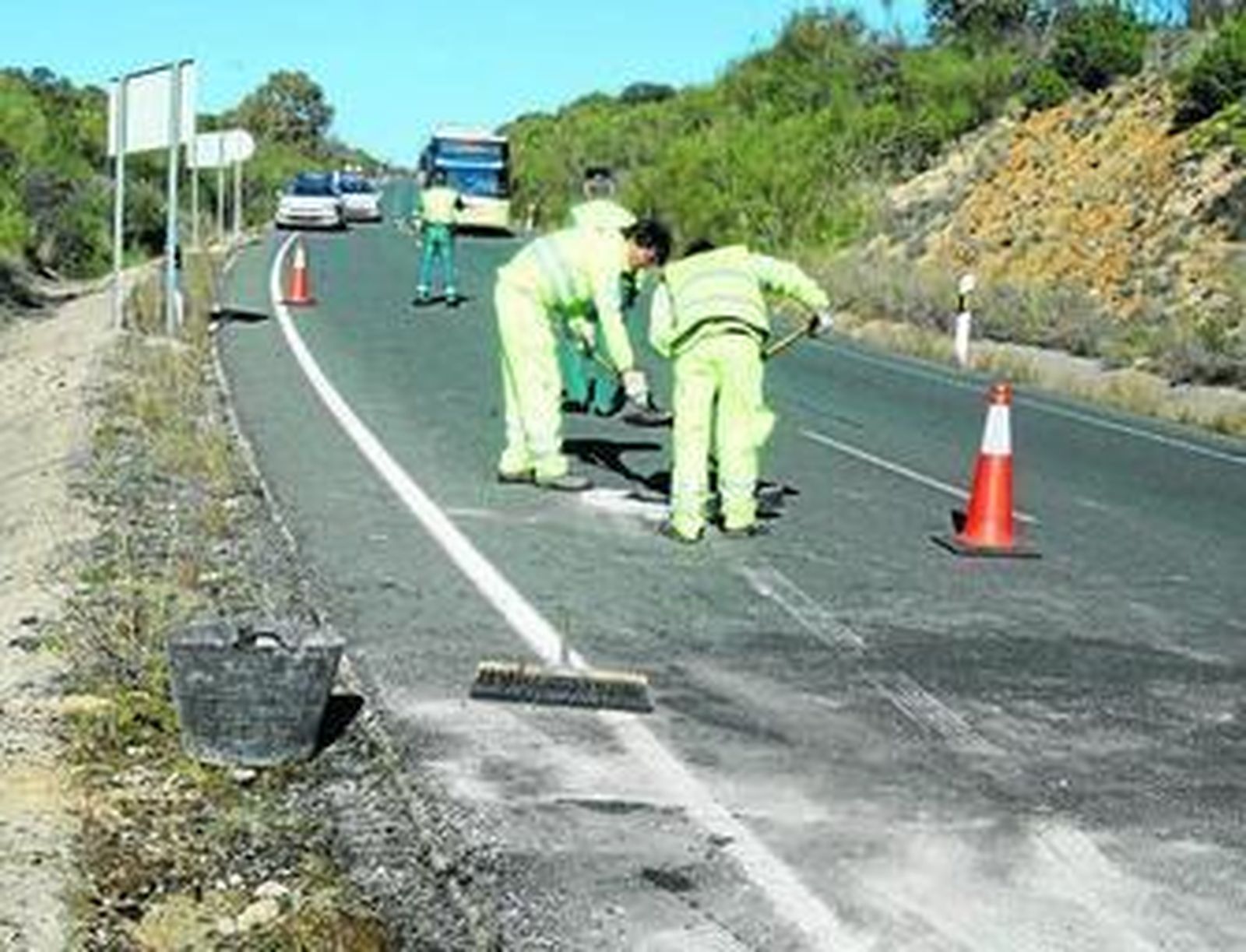 Operarios y agentes de la Guardia Civil en una carretera de la Sierra Norte tras un accidente grave.