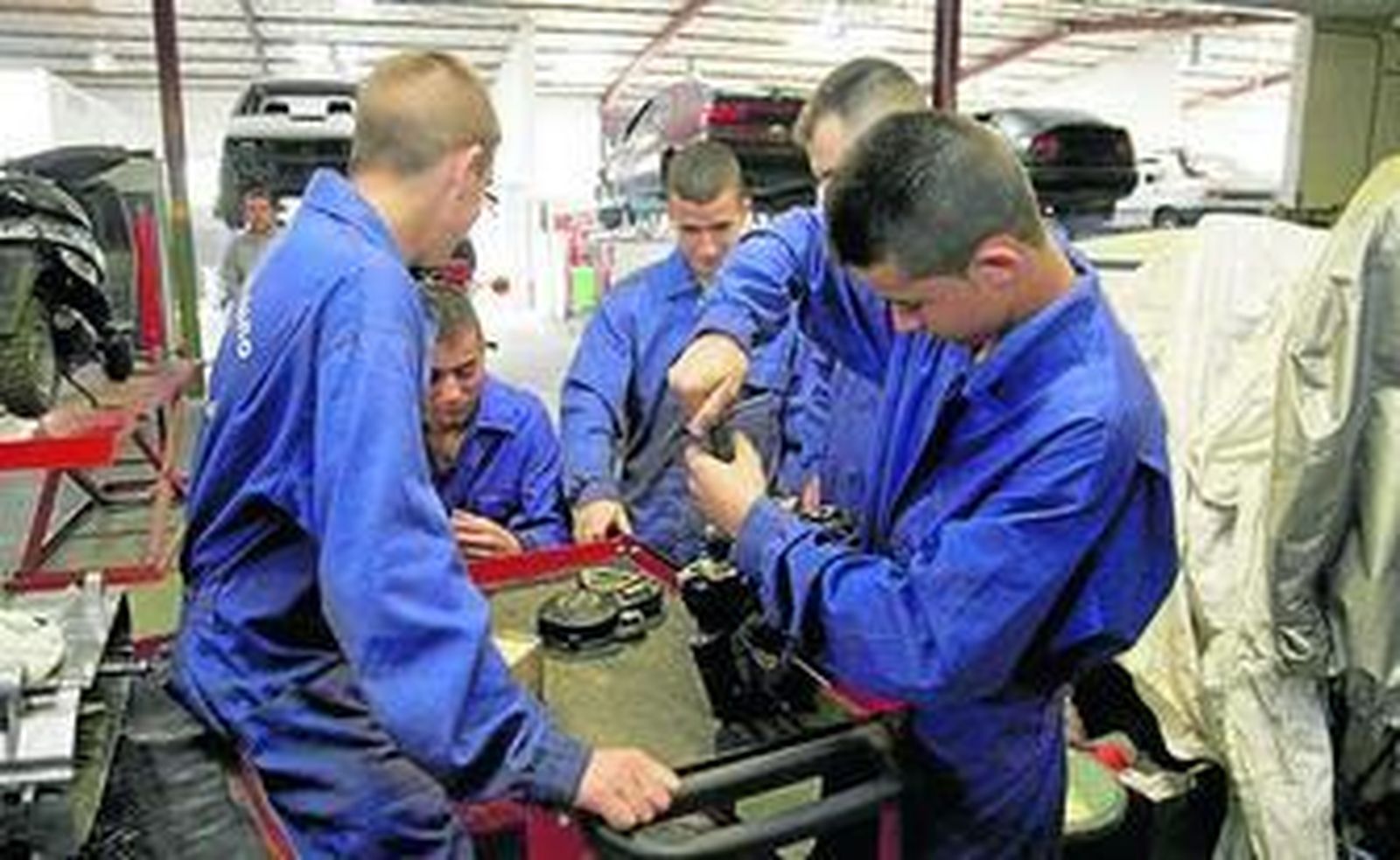 Varios estudiantes realizan prácticas en un taller.