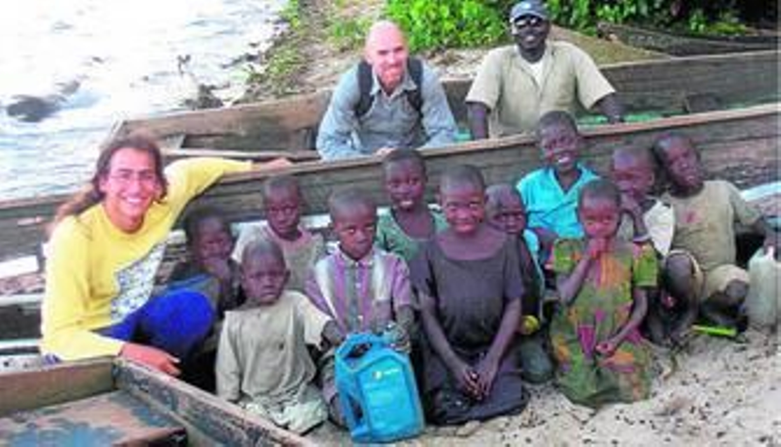 Oceanógrafos de la UCA posan junto al lago Victoria en compañía de niños africanos.