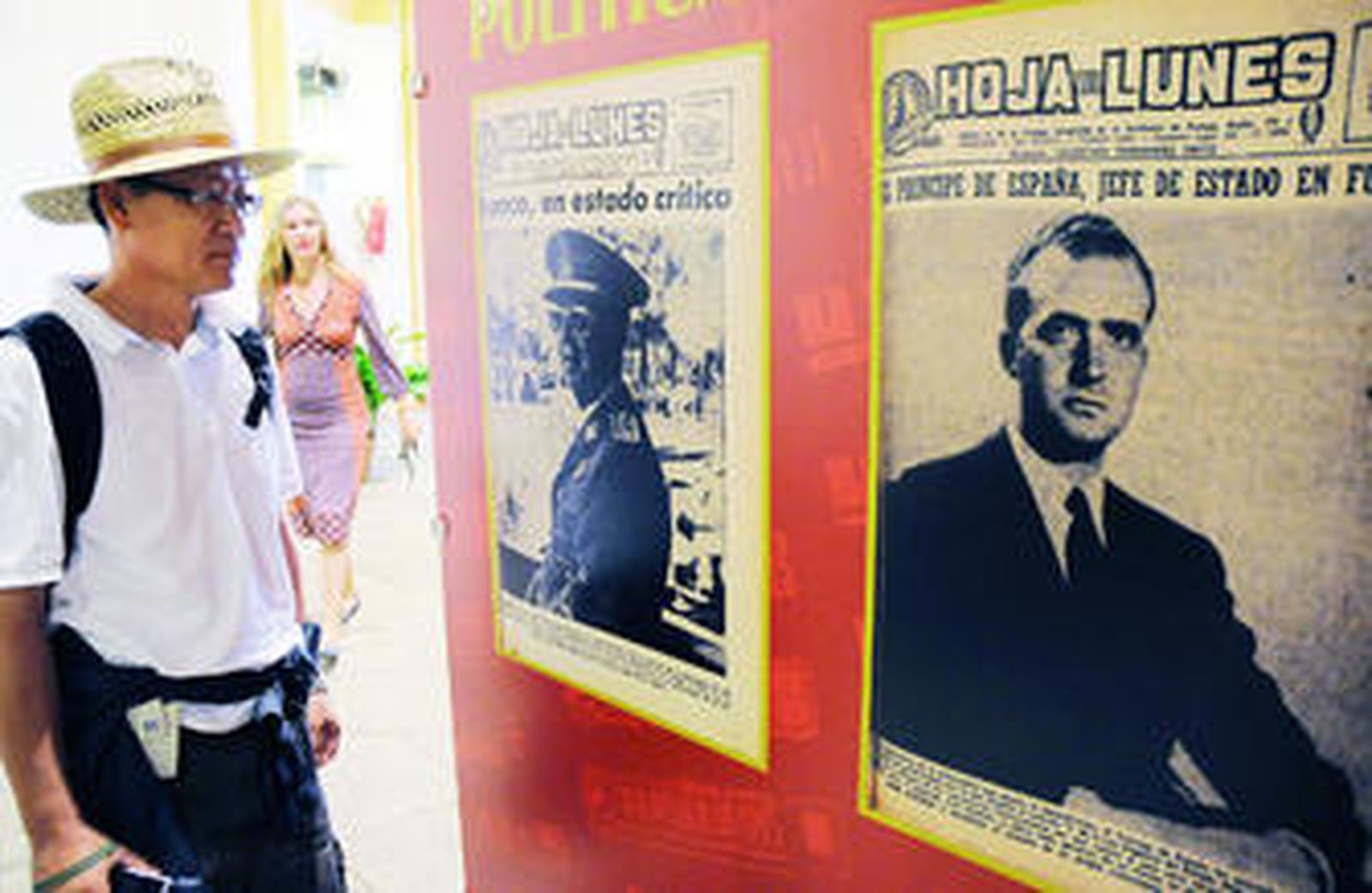 Un turista observa dos portadas de la Hoja del Lunes de 1975 con Franco y el rey Juan Carlos.