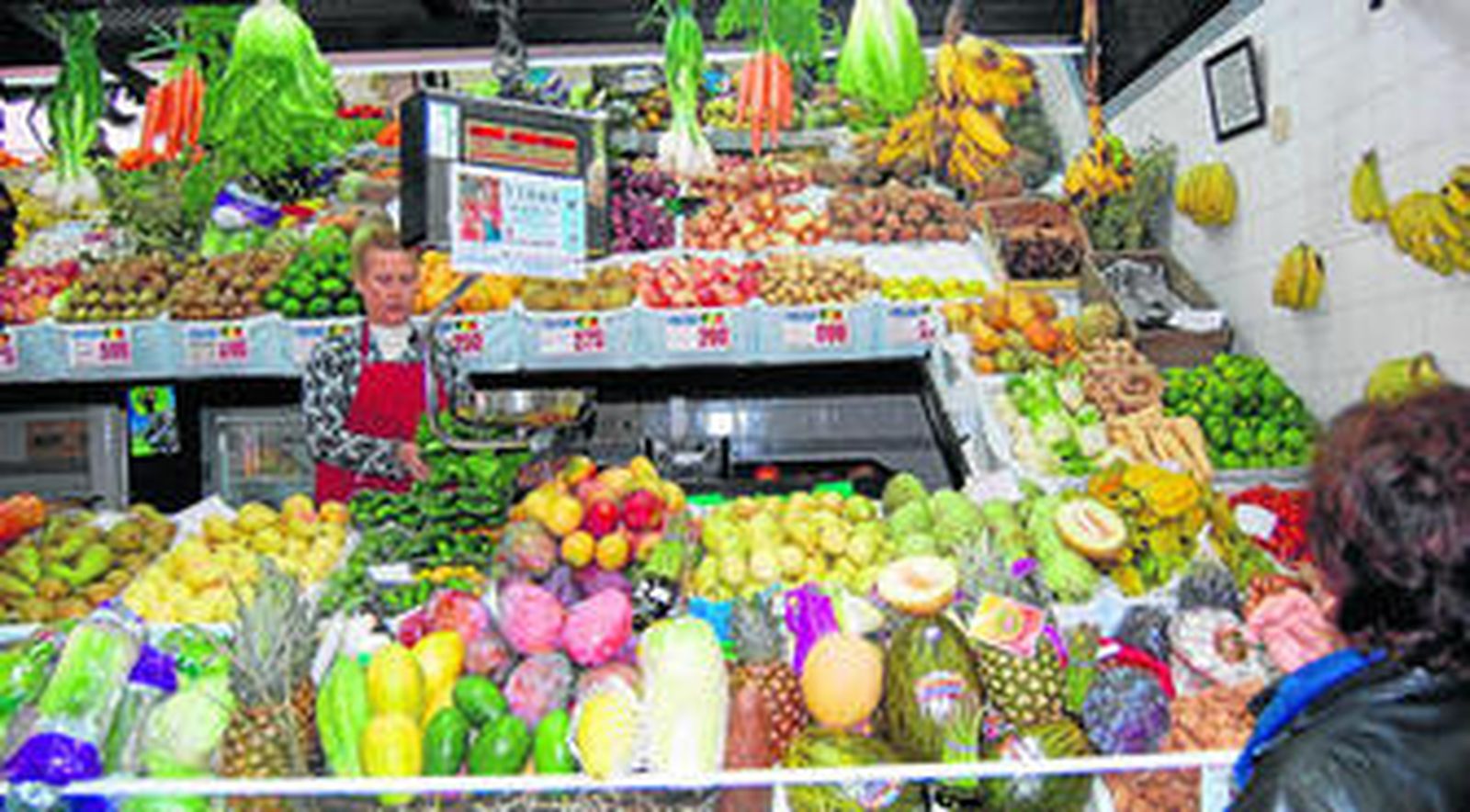 Una tendera en el mercado vende todo tipo de frutos tropicales.