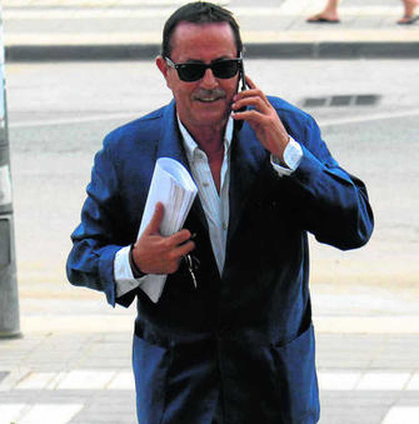 Julián Muñoz entró ayer a los juzgados hablando por teléfono.