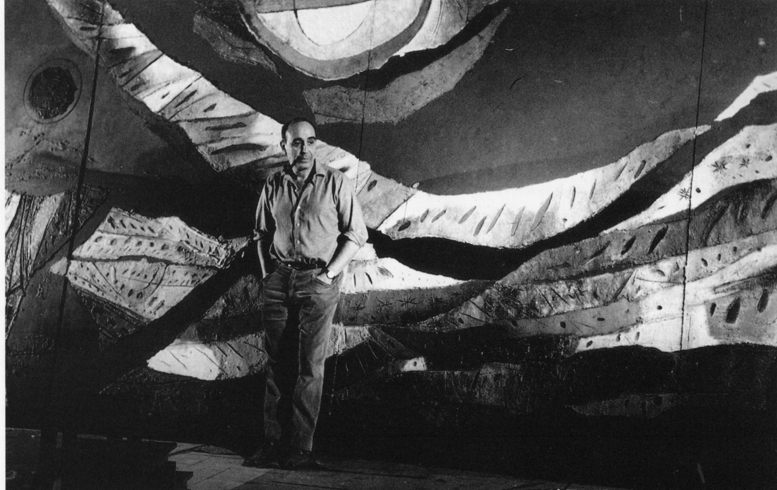 El pintor José Caballero ante el mural de 'La noche de la partida', realizado para el salón de plenos de la Diputación Provincial de Huelva.