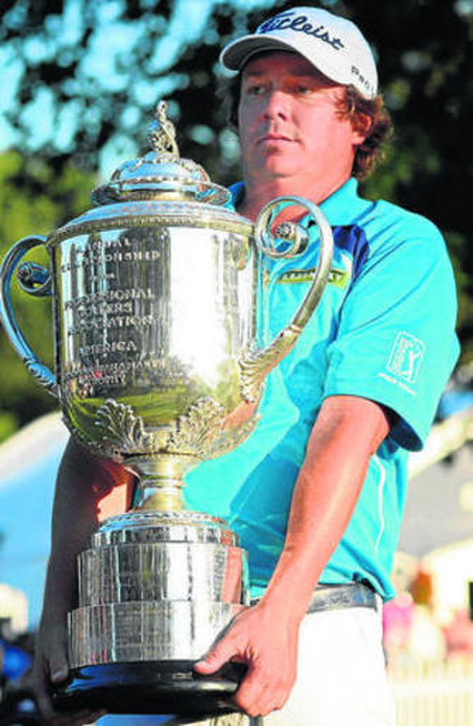 Dufner sostiene torpemente el trofeo del PGA Championship.