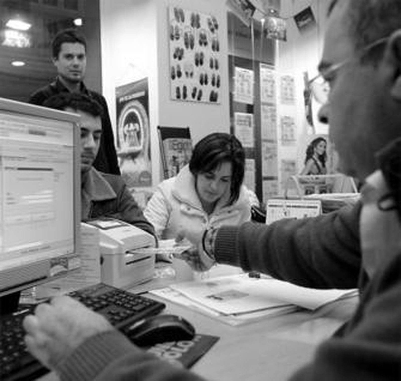 Una pareja compra sus entradas en el interior de la agencia de viajes Cádiz Tour.