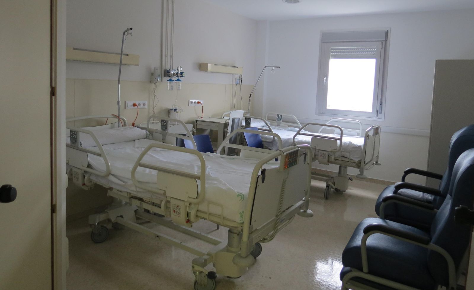 Dos camas en una habitación de un hospital público.