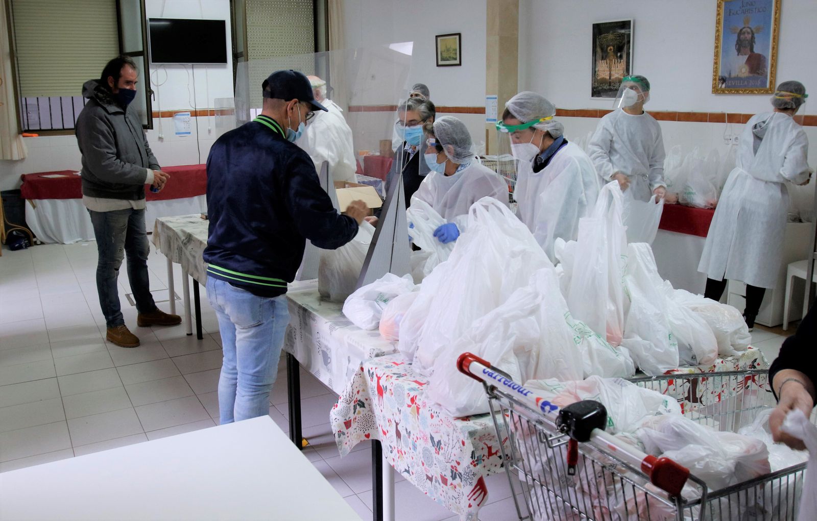 Reparto de comida a personas con necesidades en el comedor social de Triana.