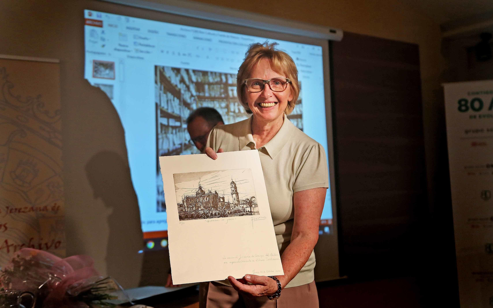 Liliane Dahlmann muestra el grabado que ha recibido como regalo por su nombramiento.