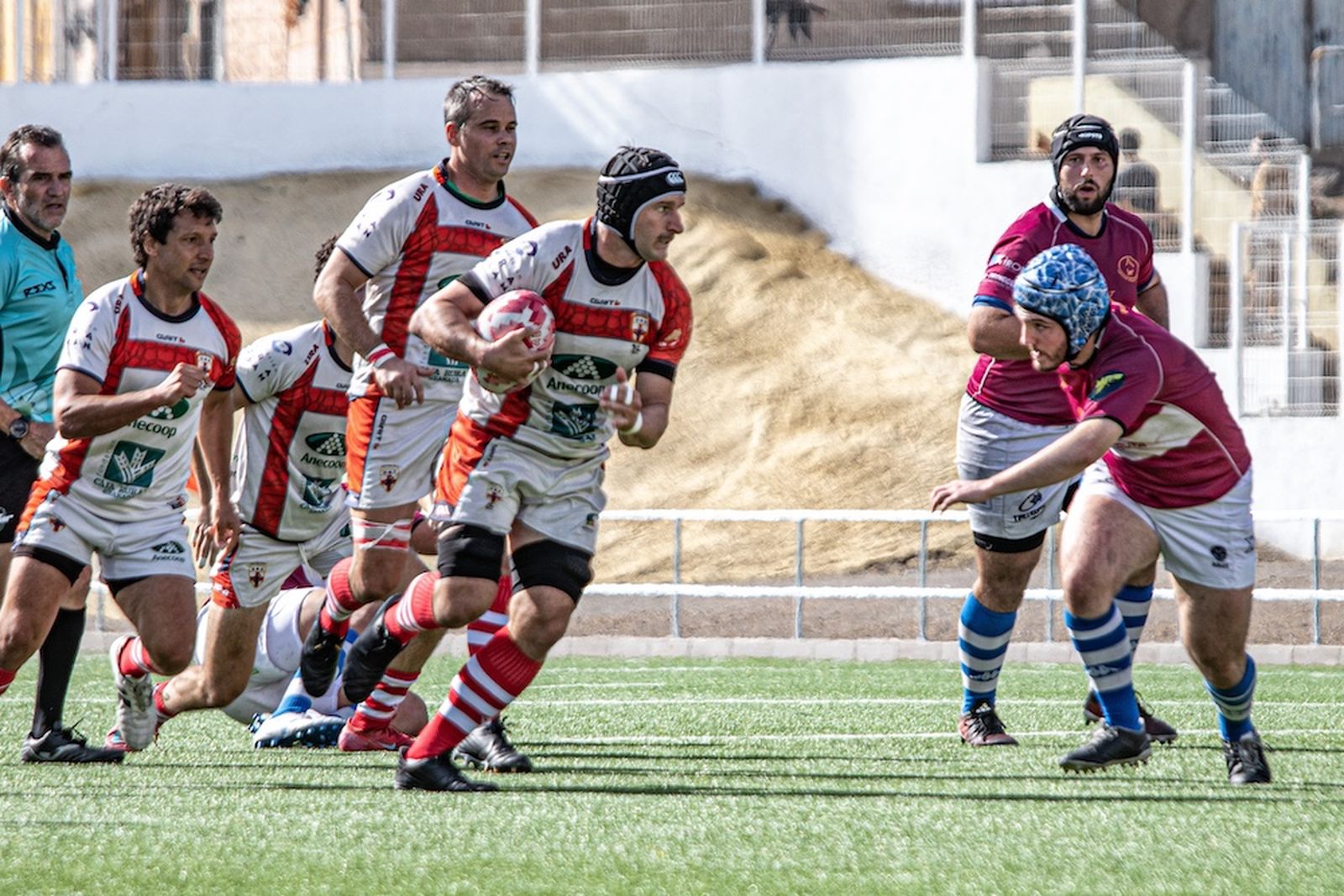 Un jugador del conjunto cruzado progresa con el oval en su posesión ante la salida de un rival en una acción del encuentro.