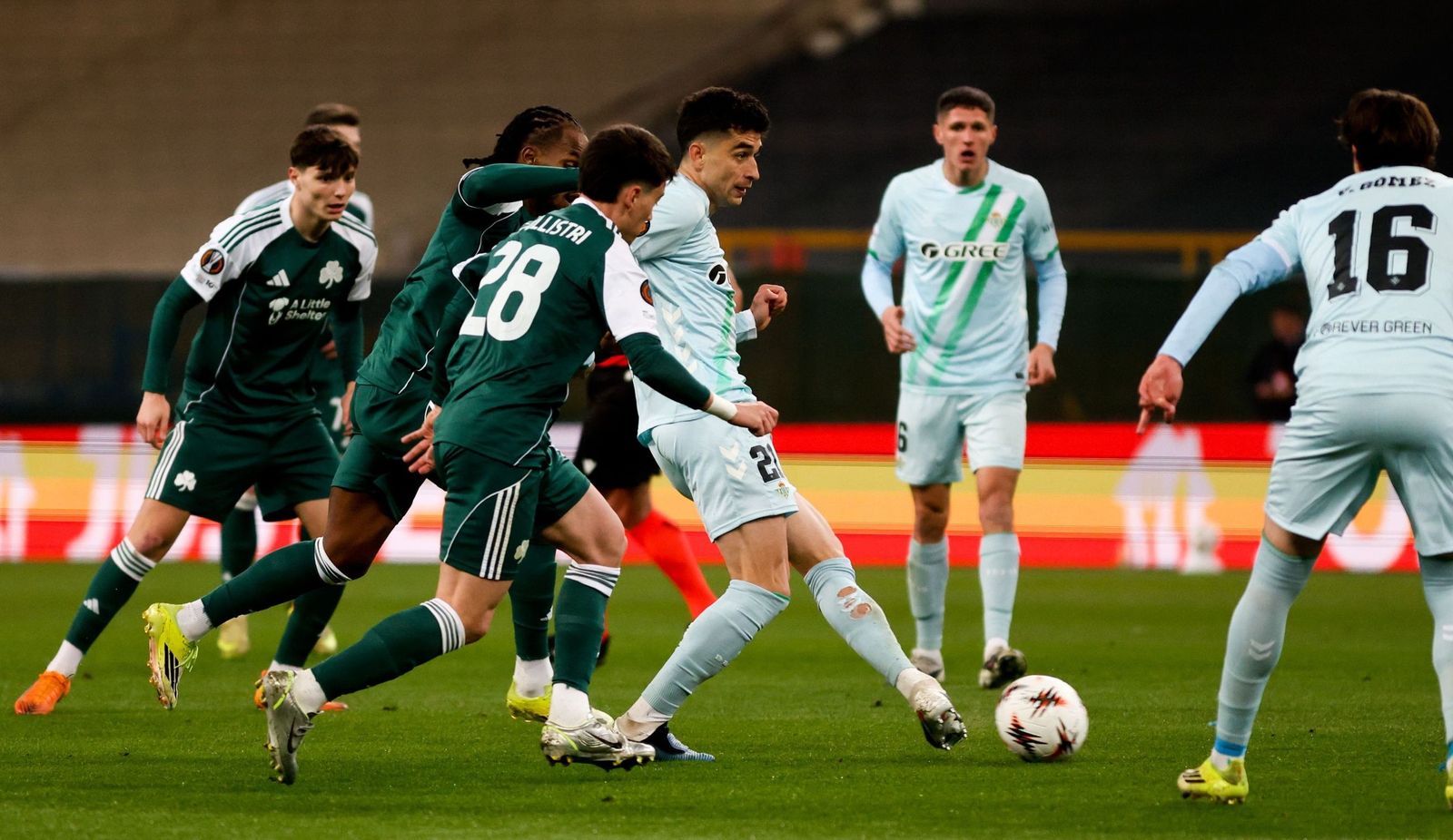 Marc Roca trata de sacar un balón jugado rodeado de futbolistas del Panathinaikos.