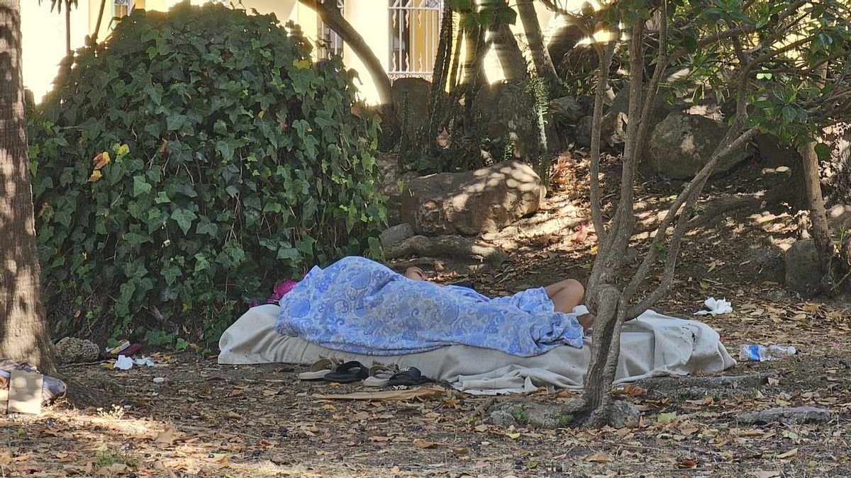 Los dos indigentes duermen en el parque, este lunes. 