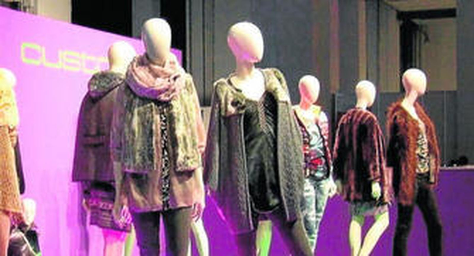 Varios maniquíes con algunos diseños del modisto en una exposición.