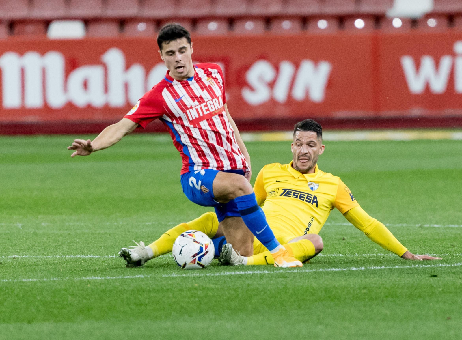 Caye Quintana va al suelo a por una pelota en el Sporting de Gijón - Málaga.