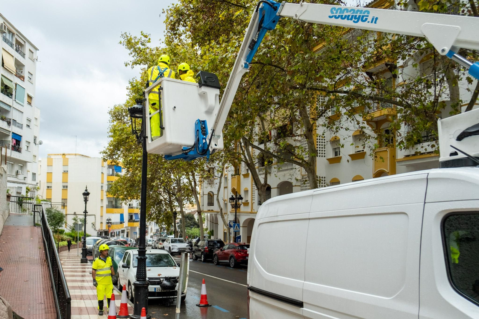 Operarios renovando las luminarias de una farola.