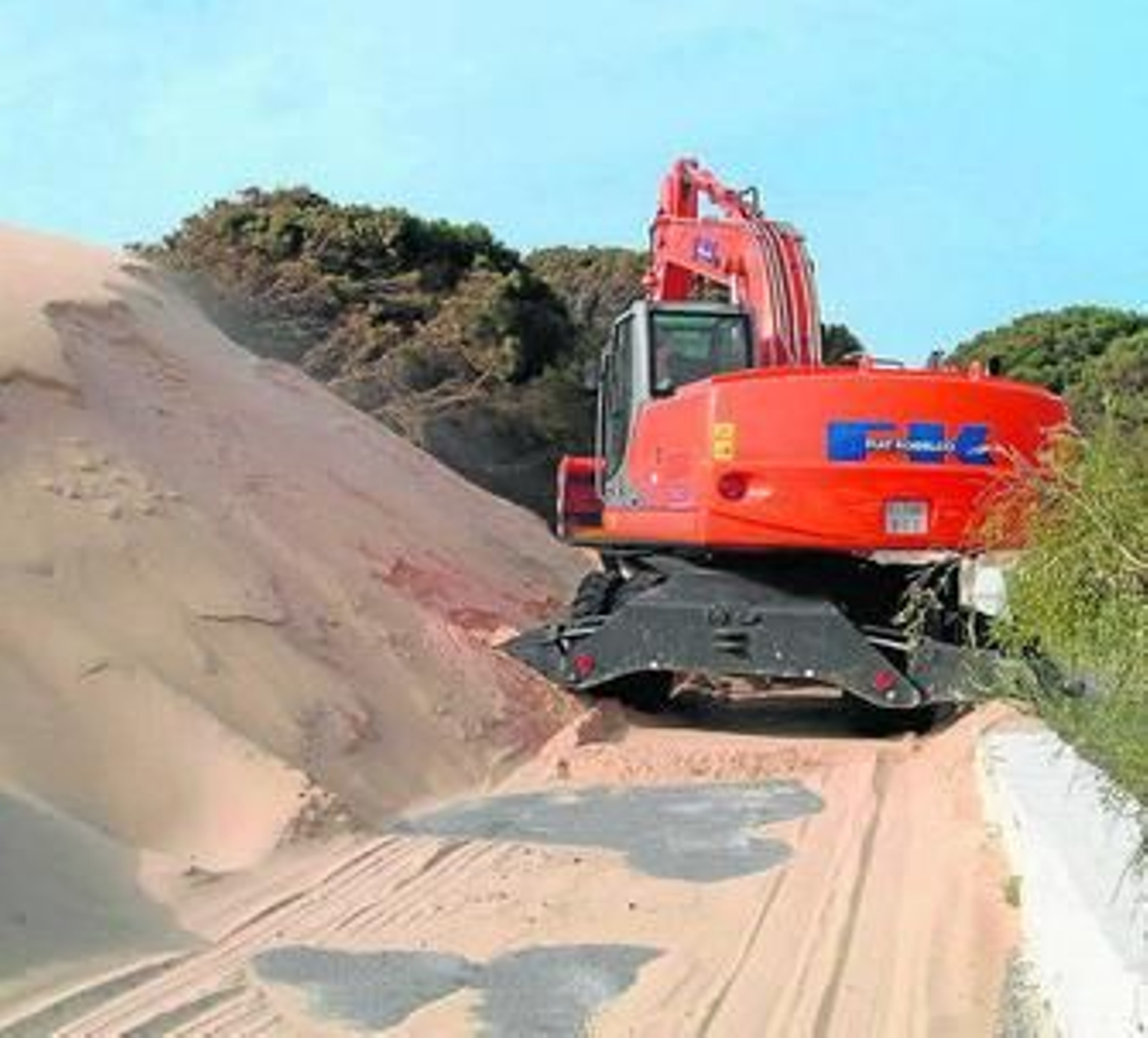 Una excavadora retira arena de la duna, en foto de archivo.