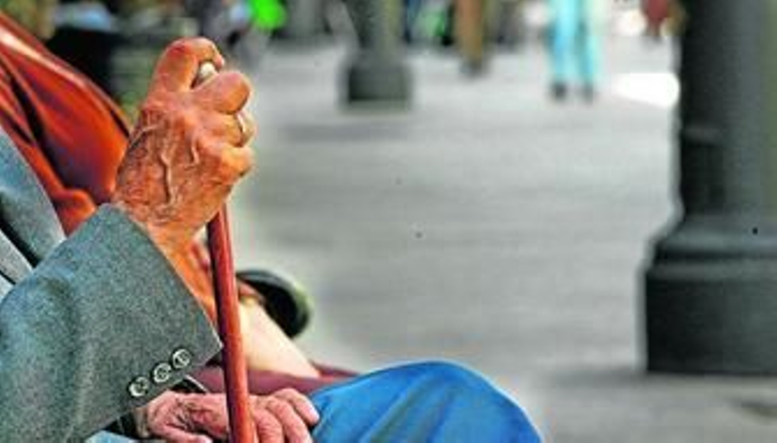 Un señor mayor reposa en un banco de calle Larga, en una imagen retrospectiva.