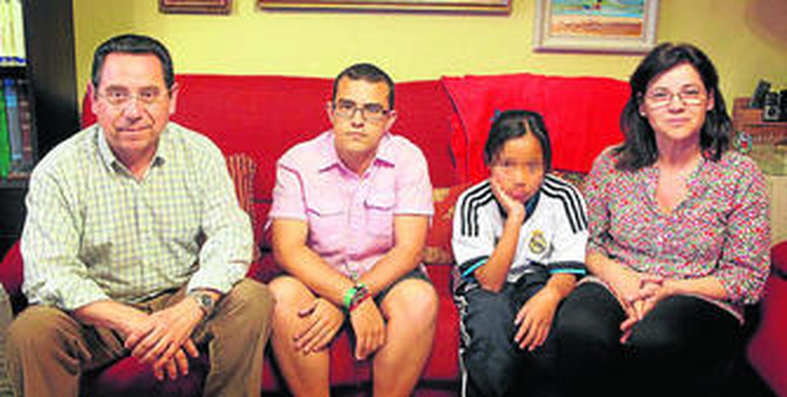 La familia al completo, Manolo, Antonio, Laura y Luisa, posa en el salón de su casa.