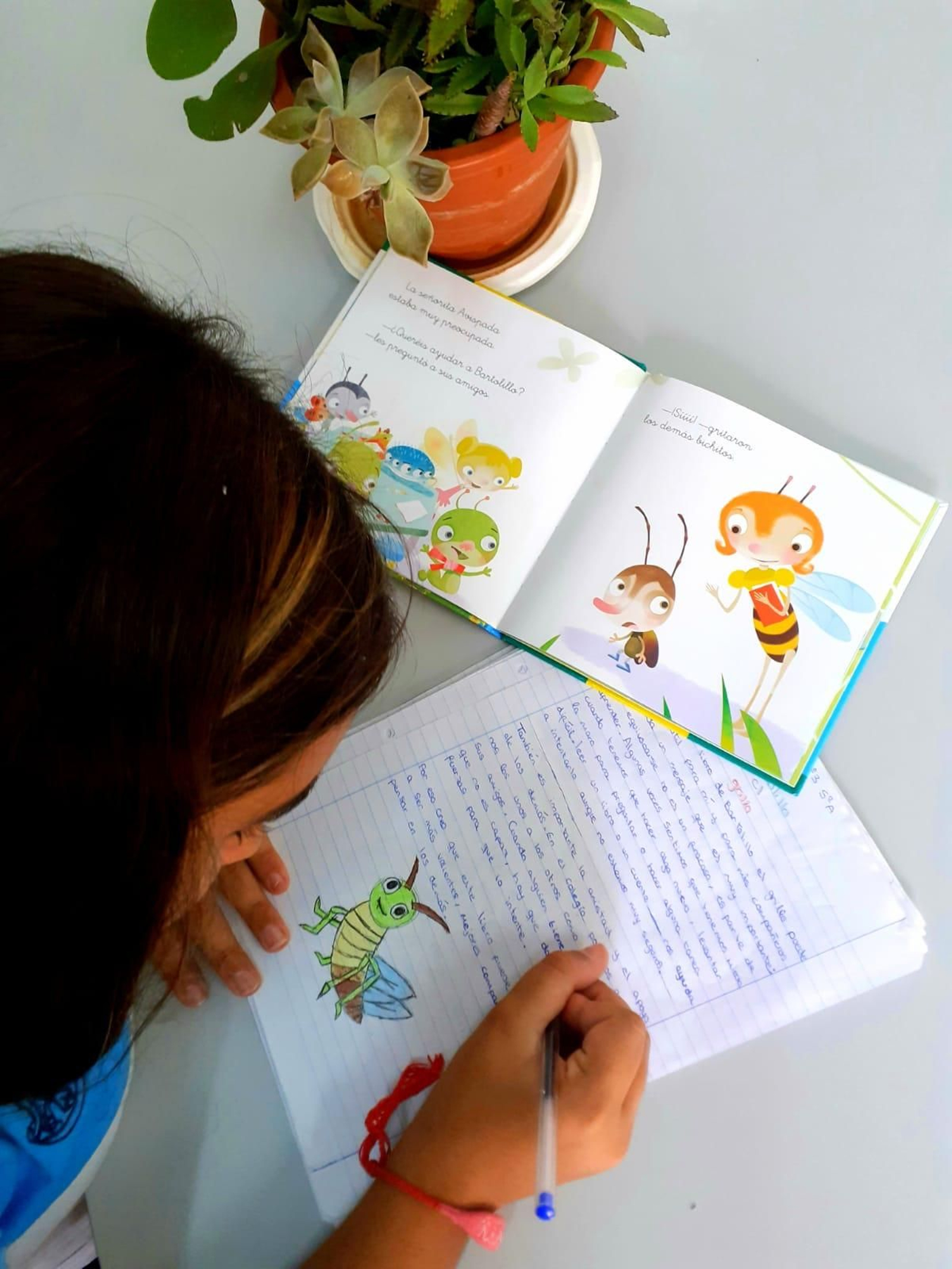 Una alumna realiza una actividad con el libro.