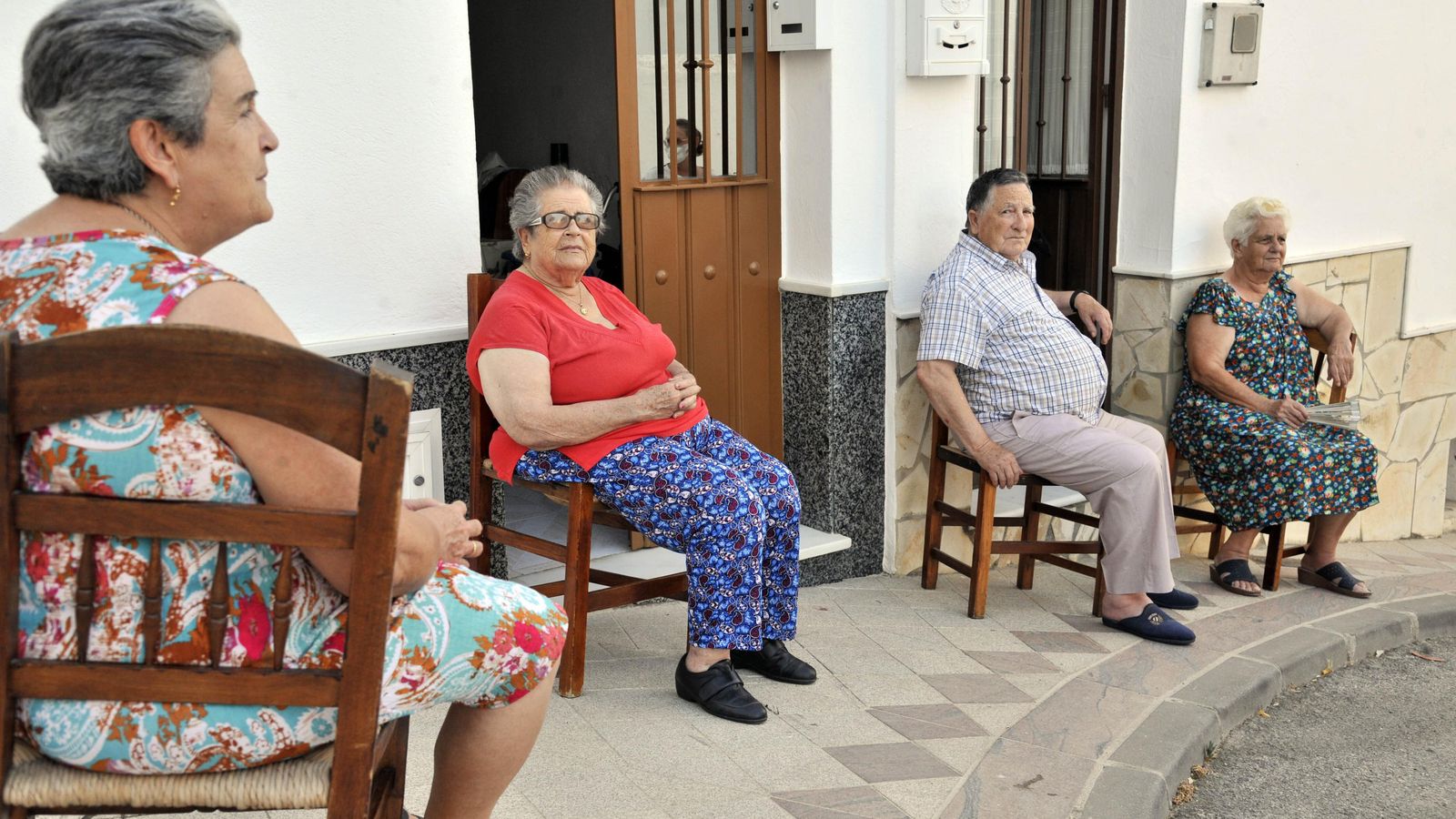 Cuatro personas con sus sillas de neas en sus puertas Cuatro personas con sus sillas de neas en sus puertas