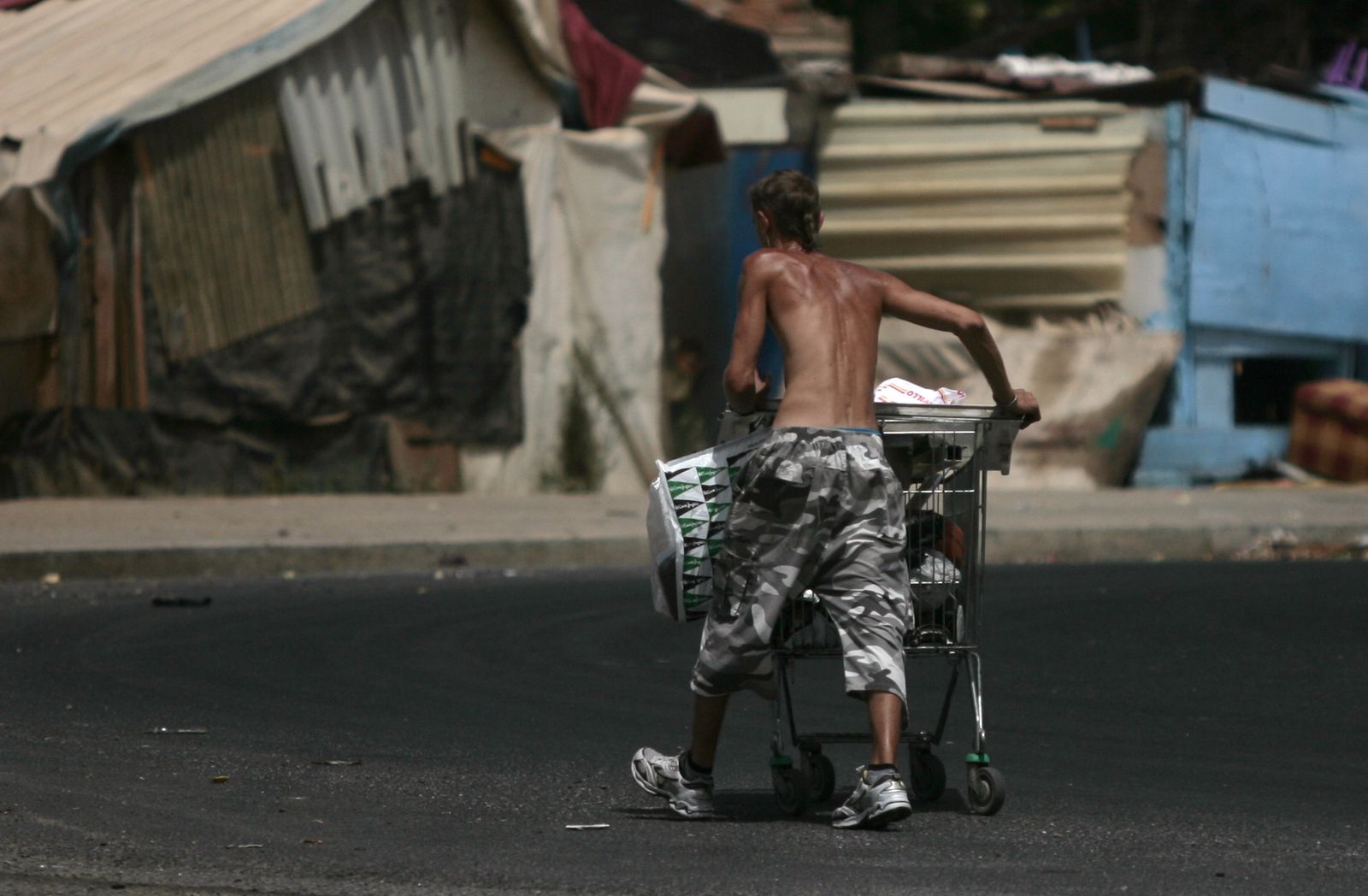 Un joven traslada chatarra en el poblado chabolista de El Vacie.