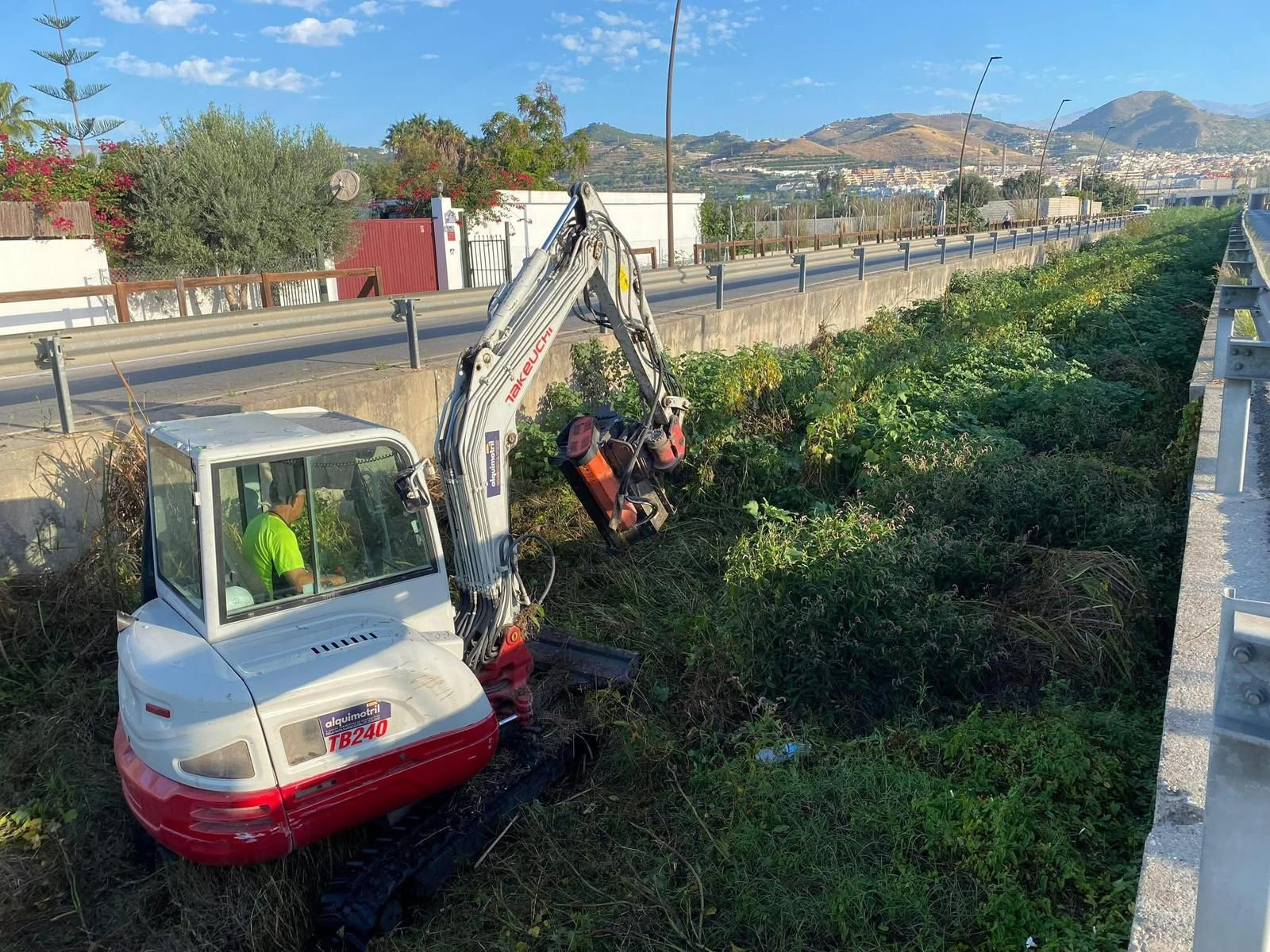Un técnico realiza labores de desbroce en el cauce de la rambla.
