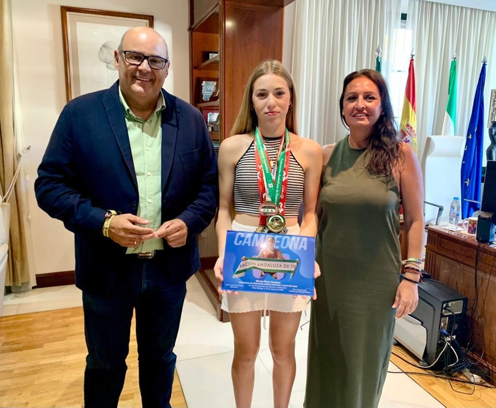 El alcalde de Vélez-Málaga, Jesús Lupiáñez, acompañado por la concejala de Deportes, Rocío Ruiz y la joven triatleta, Marta Pérez Campos