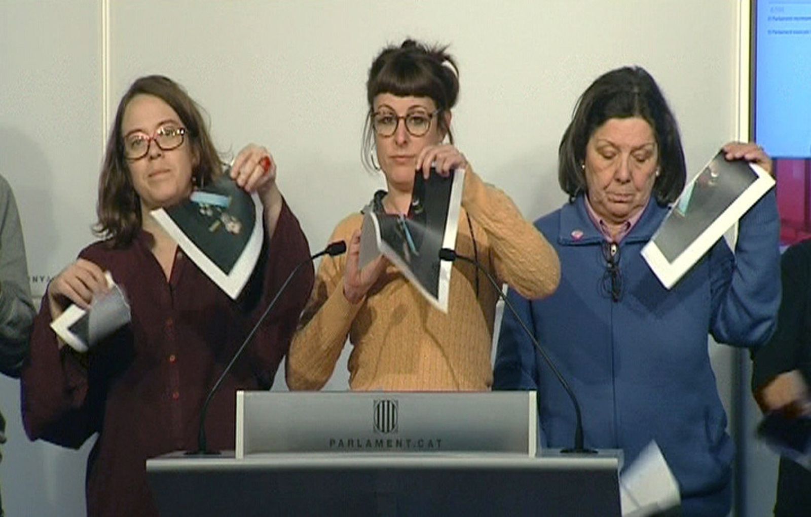 Tres de los diputados de la CUP rompen imágenes de Felipe VI en rueda de prensa.