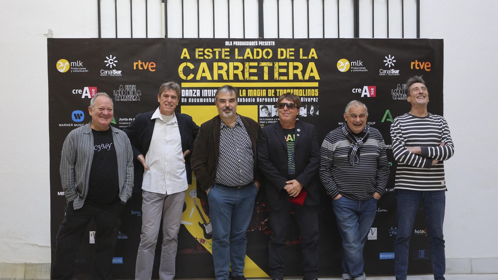 La banda y el director del documental, en el centro, posan con el cartel. La banda y el director del documental, en el centro, posan con el cartel.