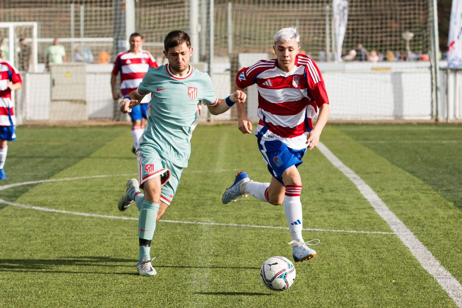 Un jugador rojiblanco presiona a uno del Atlético de Madrid.